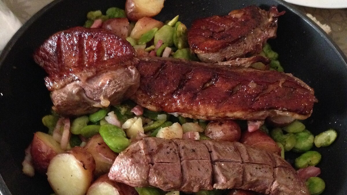 Magret de canard servi avec un accompagnement de légumes de saison