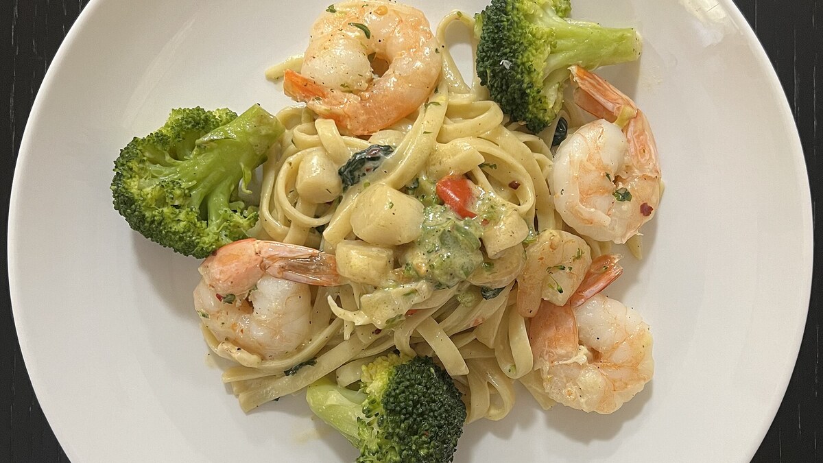 Noix de Saint-Jacques et crevettes dans une sauce à la crème servies avec des pâtes