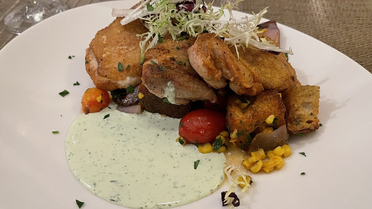 Cuisses de poulet dorées servies avec légumes et sauce