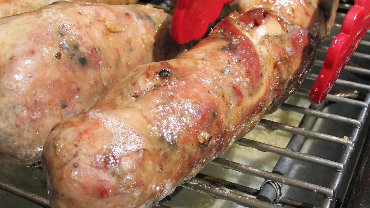 Andouillettes de Troyes en cours de cuisson sur la grille d’un barbecue