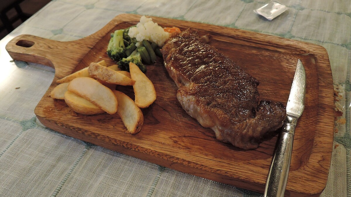 Basse côte de bœuf cuite et servie avec pommes de terre et légumes pour illustrer la cuisson à la poêle