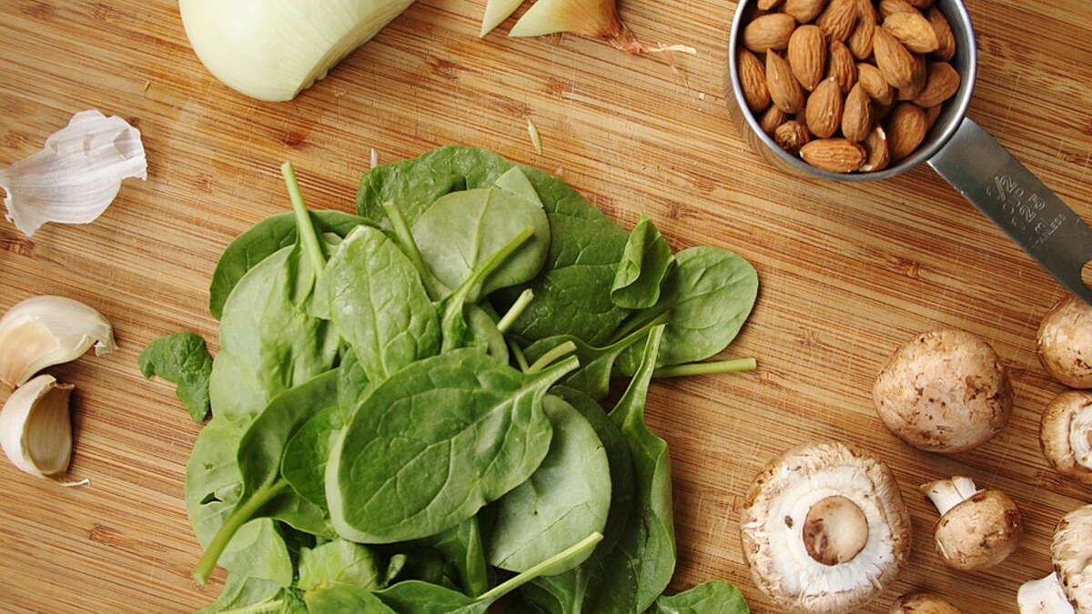 Épinards, champignons et amandes disposés pour préparer un repas adapté