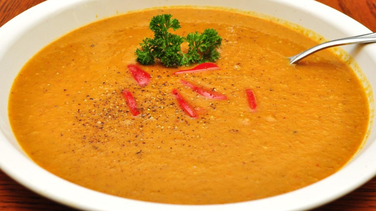 Soupe de légumes orange servie dans un grand bol blanc