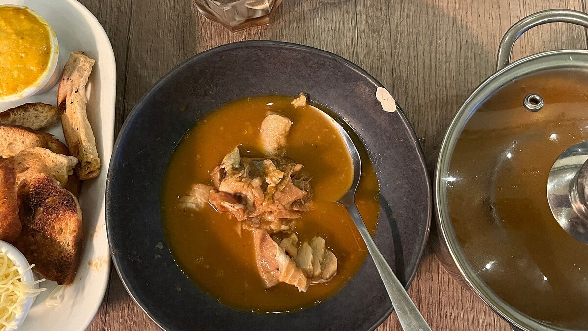 Bouillabaisse marseillaise servie avec son bouillon de poissons, des croûtons et une rouille
